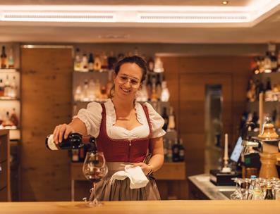 A waitress fills a glas of red wine