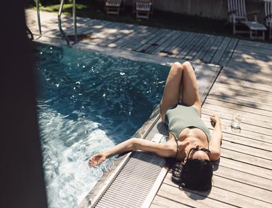 Donna prende il sole a bordo della piscina esterna