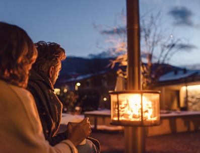 Couple drinks tea at the outdoor wood stove